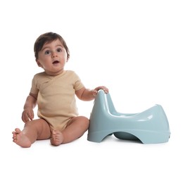 Photo of Cute little baby sitting near potty on white background