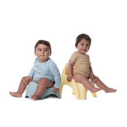 Photo of Cute little babies sitting on potties against white background