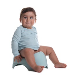 Photo of Cute little baby sitting on potty against white background