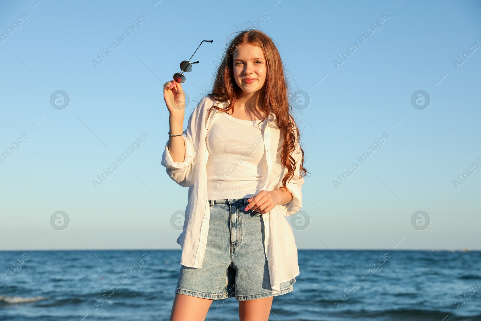 Beautiful teenage girl with sunglasses near sea Photo of Beautiful teenage girl with sunglasses near sea