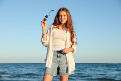 Photo of Beautiful teenage girl with sunglasses near sea