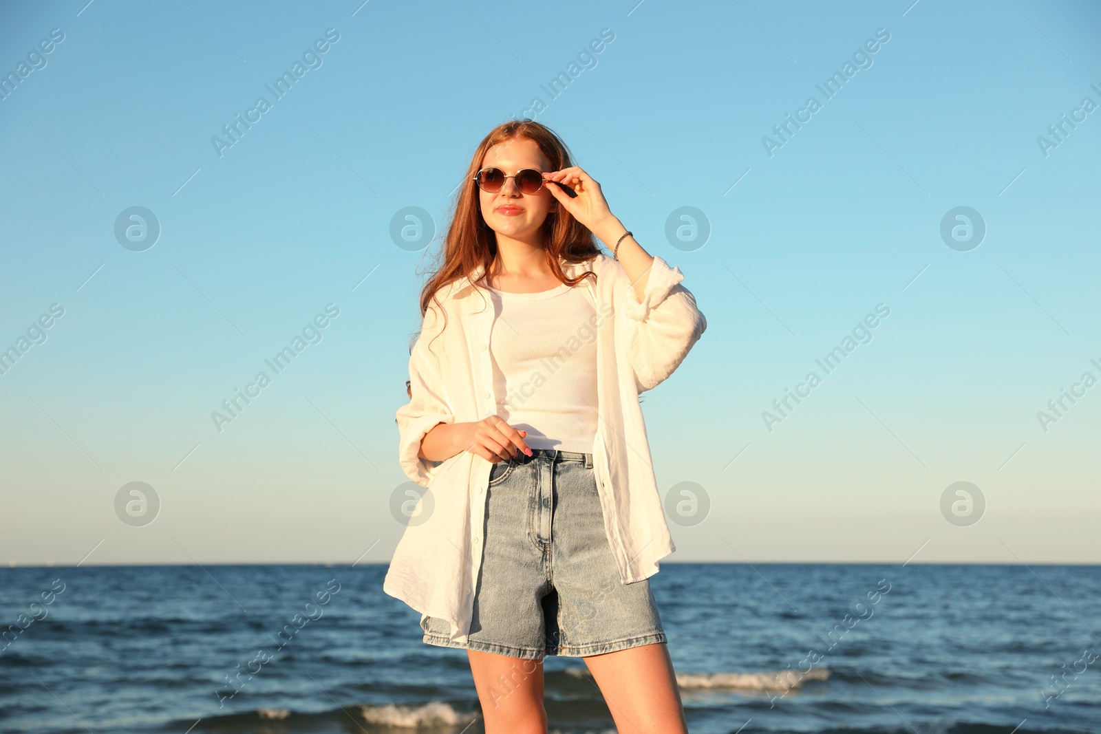 Beautiful teenage girl in sunglasses near sea Photo of Beautiful teenage girl in sunglasses near sea