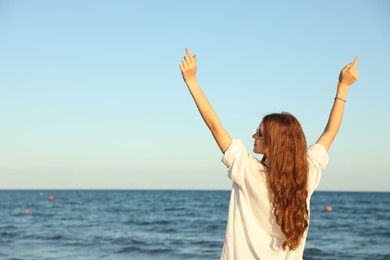 Photo of Beautiful teenage girl near sea, space for text
