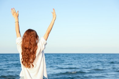 Photo of Teenage girl near sea, back view. Space for text
