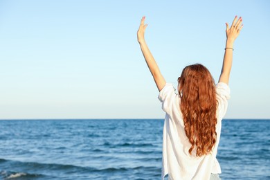 Photo of Teenage girl near sea, back view. Space for text