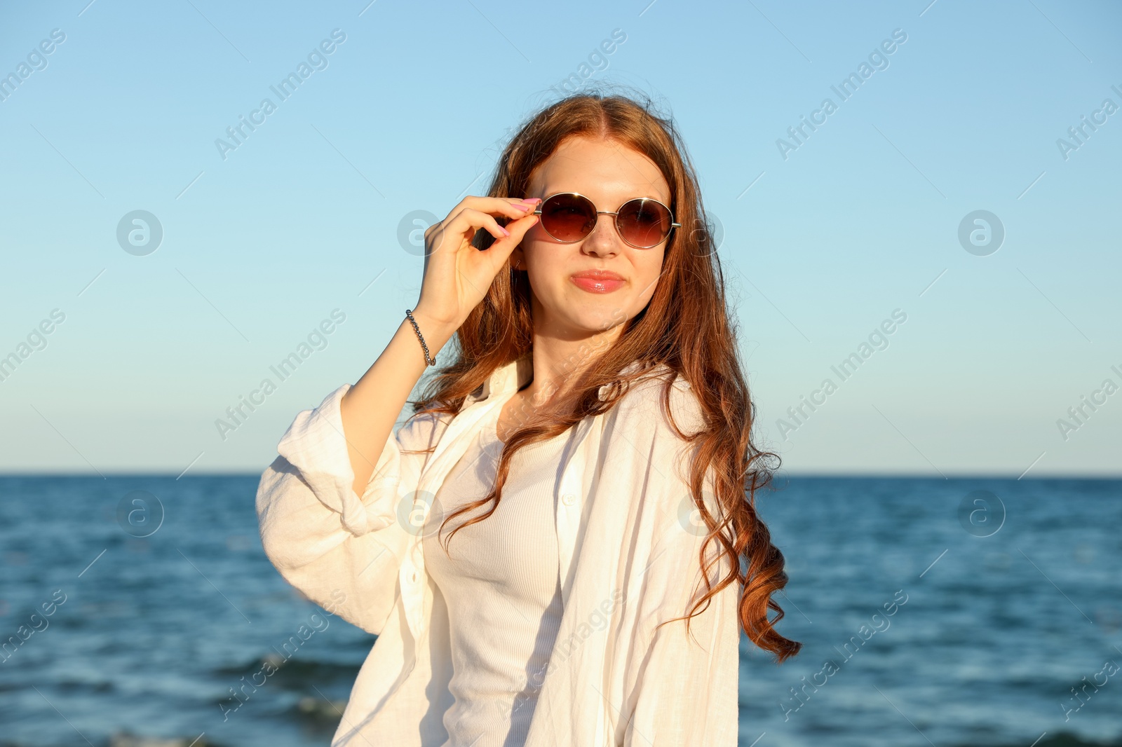 Beautiful teenage girl in sunglasses near sea Photo of Beautiful teenage girl in sunglasses near sea