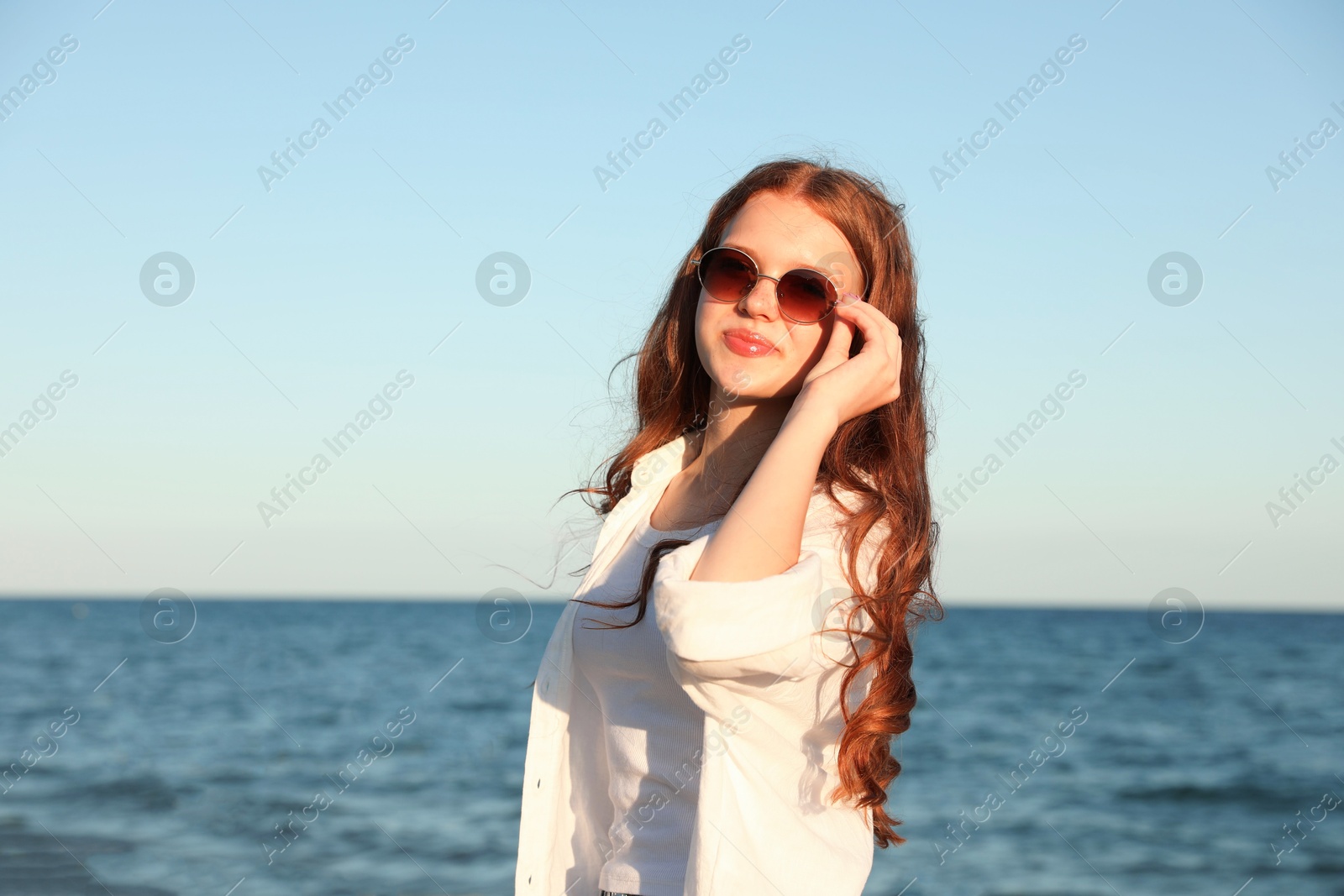 Beautiful teenage girl in sunglasses near sea Photo of Beautiful teenage girl in sunglasses near sea
