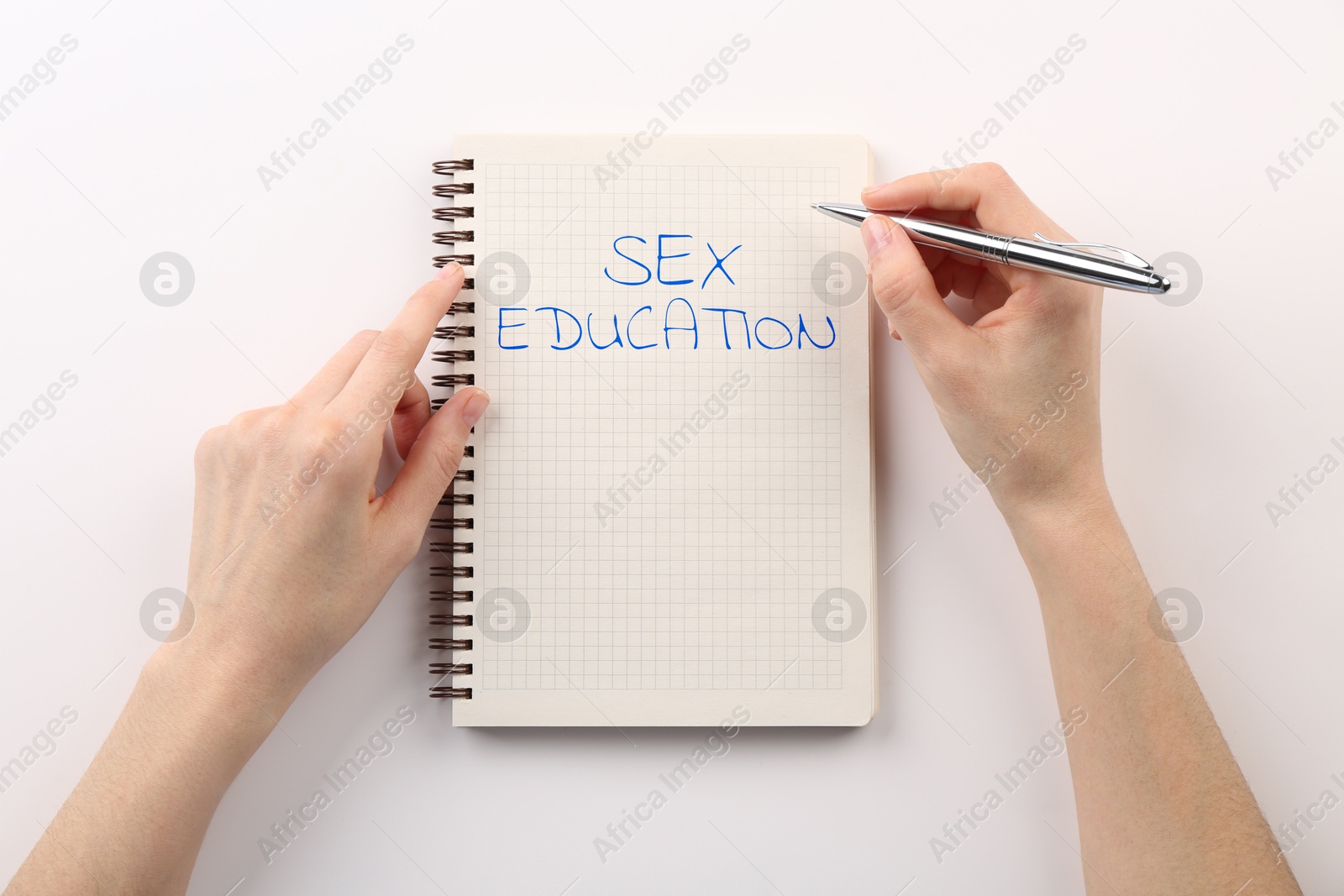 Woman writing Sex Education inscription in notebook on white background, top view Image of Woman writing Sex Education inscription in notebook on white background, top view