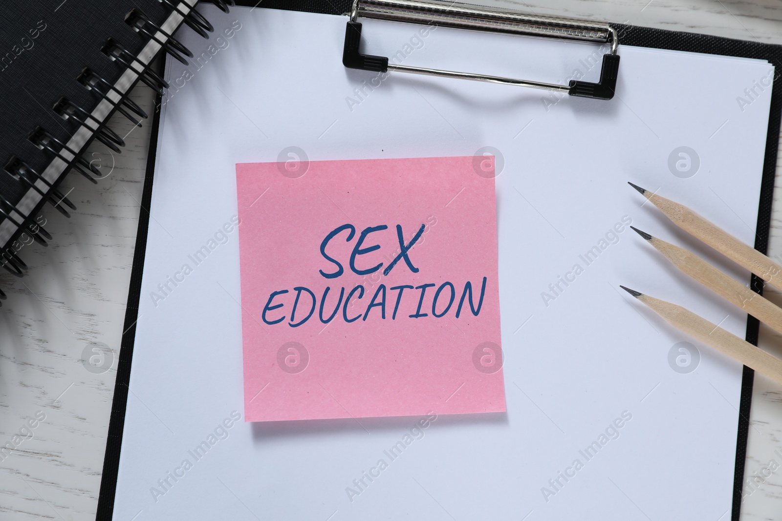 Sex Education inscription in note paper and stationery on table, top view Image of Sex Education inscription in note paper and stationery on table, top view