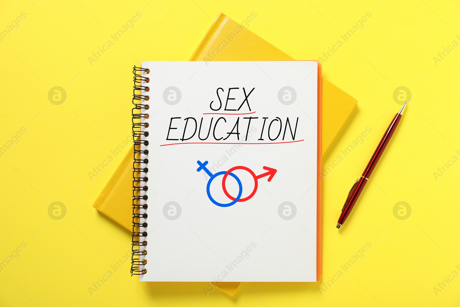 Sex Education inscription, male and female symbols in notebook and pen on yellow background, top view Image of Sex Education inscription, male and female symbols in notebook and pen on yellow background, top view