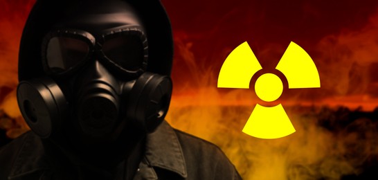 Image of Radioactive hazard, warning sign. Man in hazmat suit and gas mask against polluted city