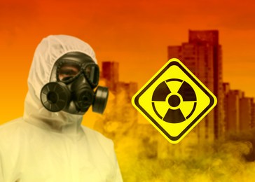 Image of Radioactive hazard, warning sign. Man in hazmat suit and gas mask against polluted city