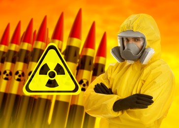 Image of Man in hazmat suit and gas mask against missiles with radioactive signs