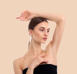 Image of Armpit epilation. Woman showing smooth underarms after hair removal against beige background