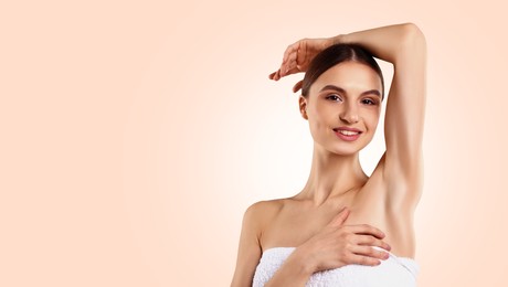 Image of Armpit epilation. Woman showing smooth underarms after hair removal against beige background