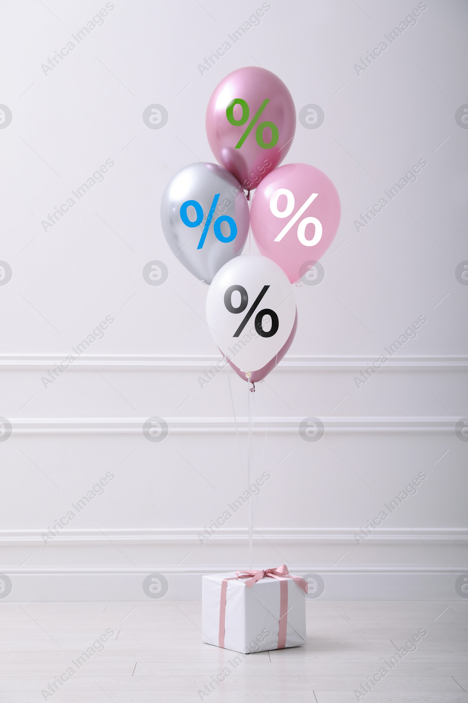 Balloons with percent signs and gift box in room. Hot sale, special offer Image of Balloons with percent signs and gift box in room. Hot sale, special offer