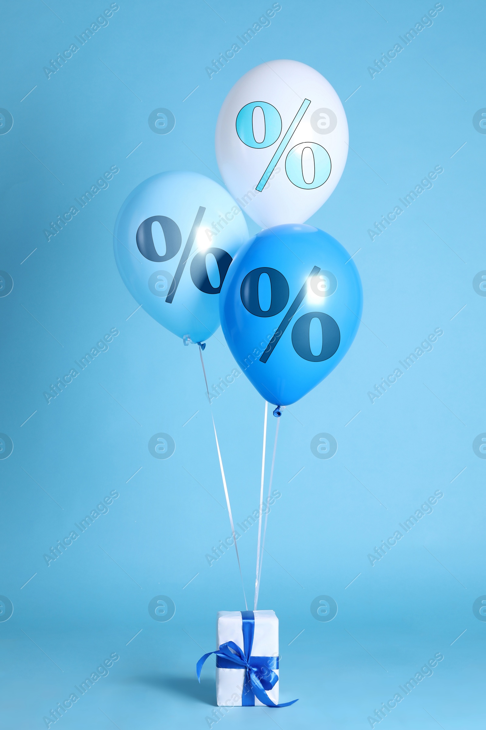 Balloons with percent signs and gift box on light blue background. Hot sale, special offer Image of Balloons with percent signs and gift box on light blue background. Hot sale, special offer