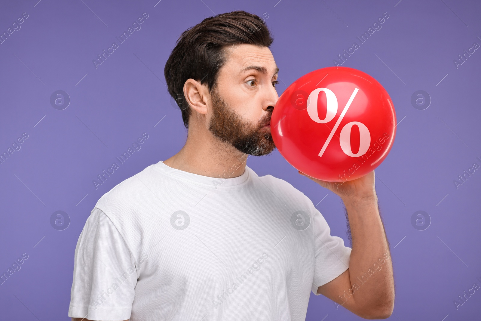 Man inflating red balloon with percent sign against purple background. Hot sale, special offer Image of Man inflating red balloon with percent sign against purple background. Hot sale, special offer