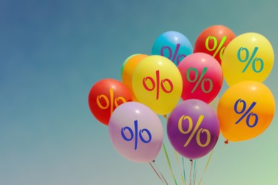 Image of Colorful balloons with percent signs against sky. Hot sale, special offer