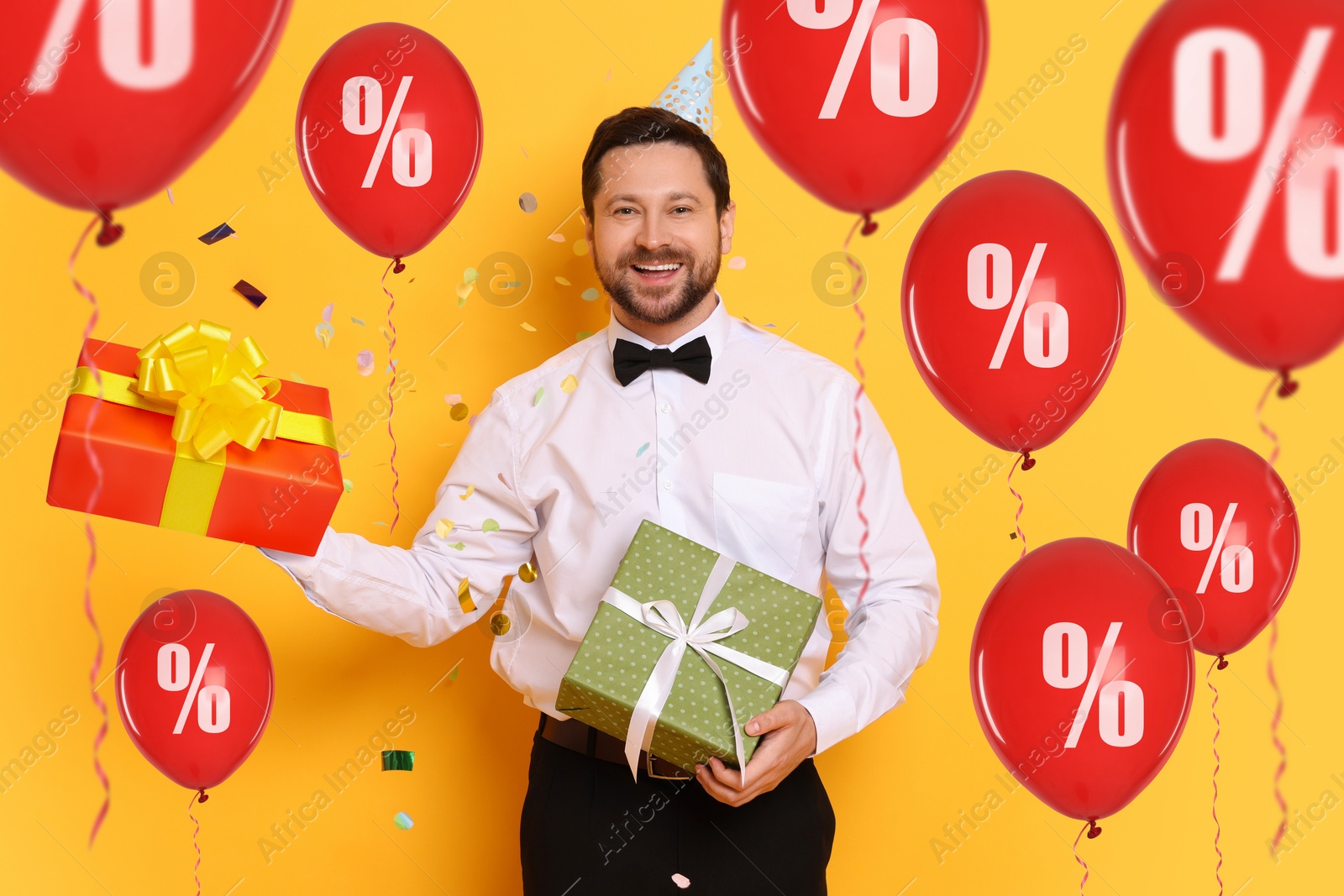 Hot sale, special offer. Happy man holding gift boxes on orange background. Colorful balloons with percent signs around him Image of Hot sale, special offer. Happy man holding gift boxes on orange background. Colorful balloons with percent signs around him