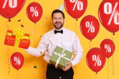 Image of Hot sale, special offer. Happy man holding gift boxes on orange background. Colorful balloons with percent signs around him