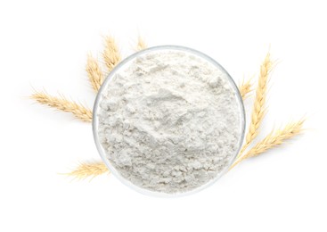 Image of Wheat flour in bowl and spikelets on white background, top view