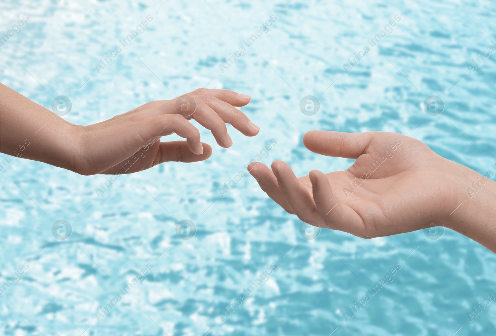 Image of Man and woman reaching to each other against seascape, closeup of hands