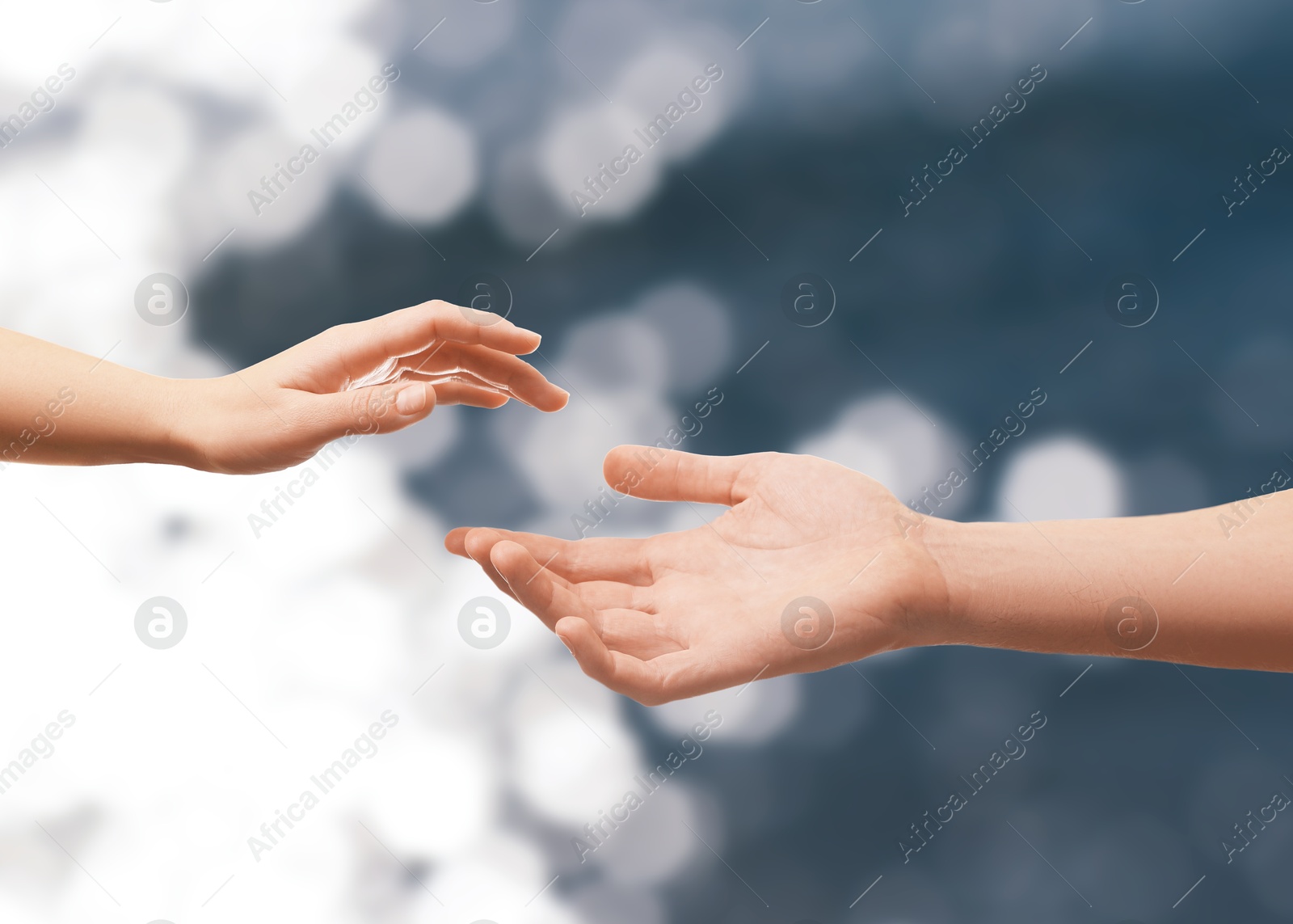 Image of Man and woman reaching to each other against seascape, closeup of hands