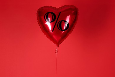 Image of Heart-shaped balloon with percent sign against red background. Hot sale, special offer