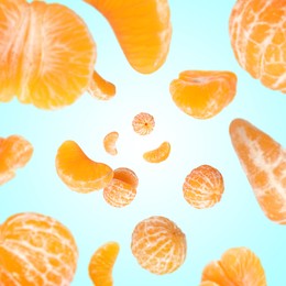 Image of Sweet tangerines whirling in air against light blue gradient background