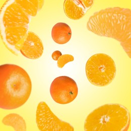 Image of Sweet tangerines whirling in air against yellow background