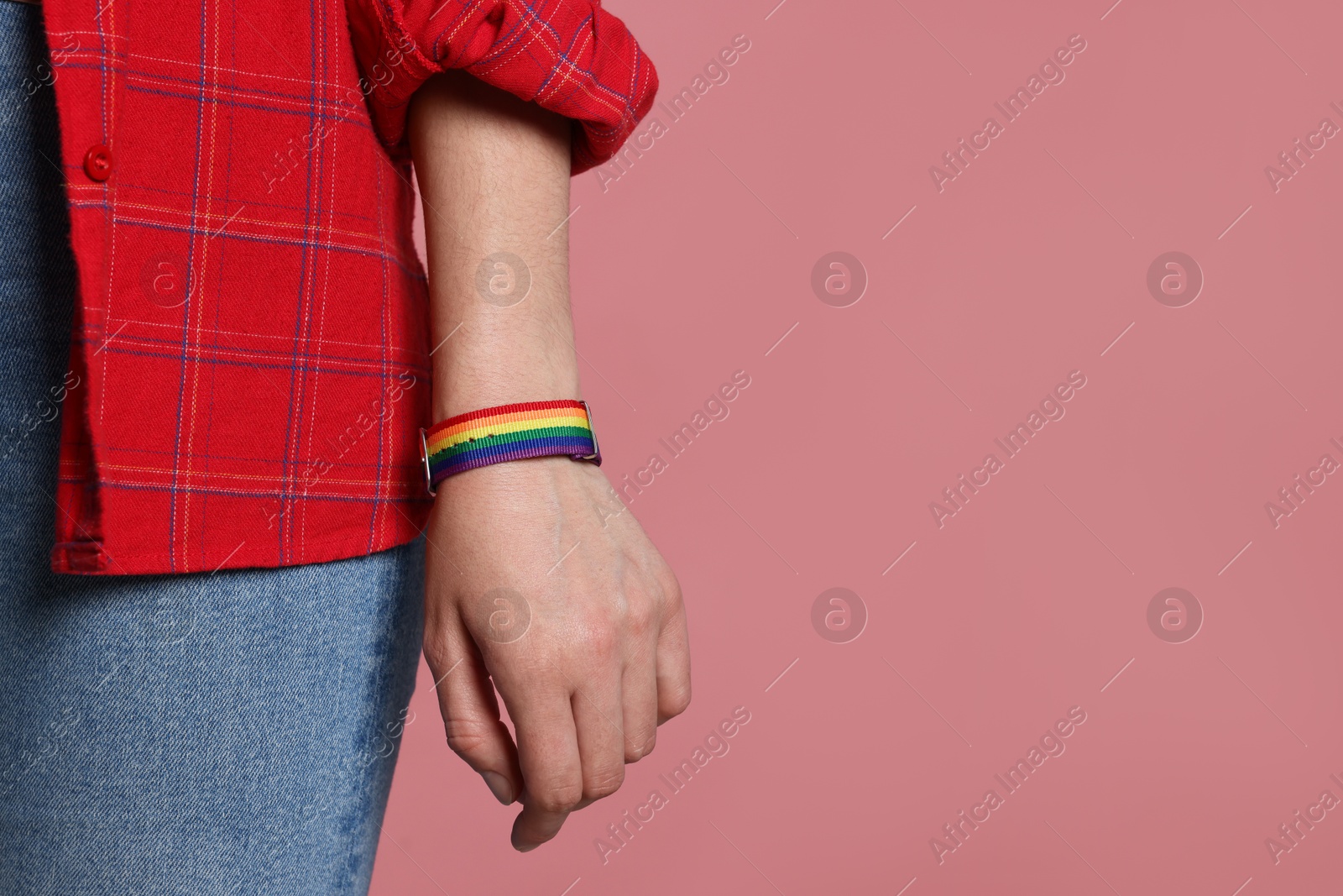 LGBT concept. Woman in rainbow wristband on pink background, closeup. Space for text Photo of LGBT concept. Woman in rainbow wristband on pink background, closeup. Space for text