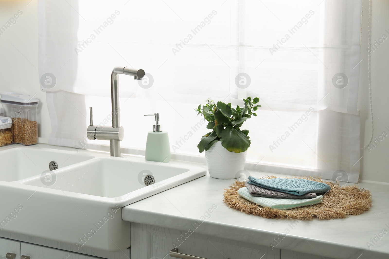 Photo of Clean waffle towels on wicker mat near sink