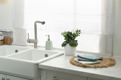 Photo of Clean waffle towels on wicker mat near sink