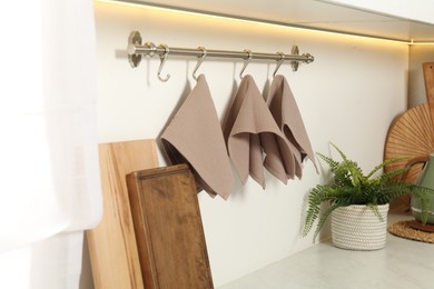 Photo of Clean waffle towels hanging on hook rack in kitchen