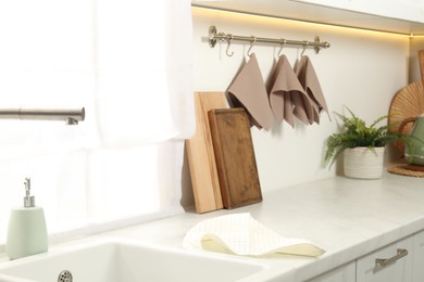 Photo of Clean waffle towels hanging on hook rack in kitchen