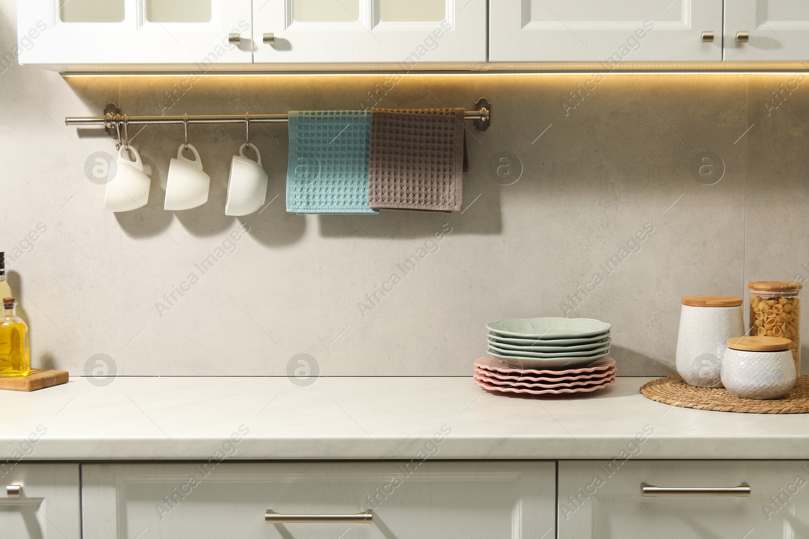 Photo of Clean waffle towels and cups hanging on hook rack above counter in kitchen