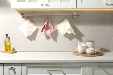 Photo of Clean waffle towels hanging on hook rack above counter in kitchen
