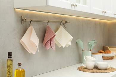 Photo of Clean waffle towels hanging on hook rack above counter in kitchen