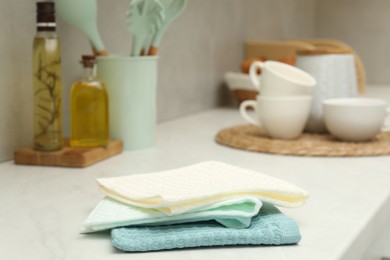 Photo of Waffle towels and dishware on white counter, closeup