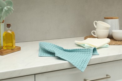 Photo of Waffle towels and dishware on white counter near grey wall