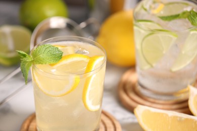 Photo of Tasty citrus cocktails with mint in glasses on table, closeup