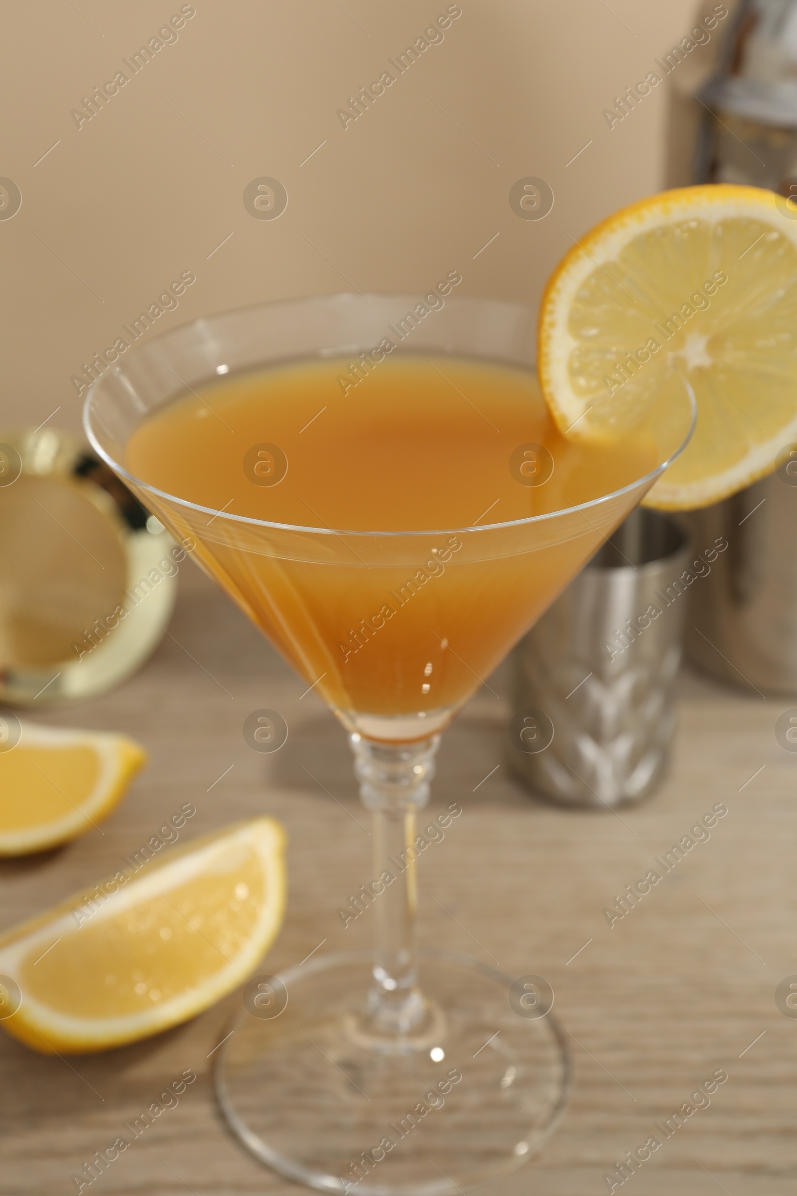 Tasty lemon cocktail in glass and bartender equipment on wooden table, closeup Photo of Tasty lemon cocktail in glass and bartender equipment on wooden table, closeup