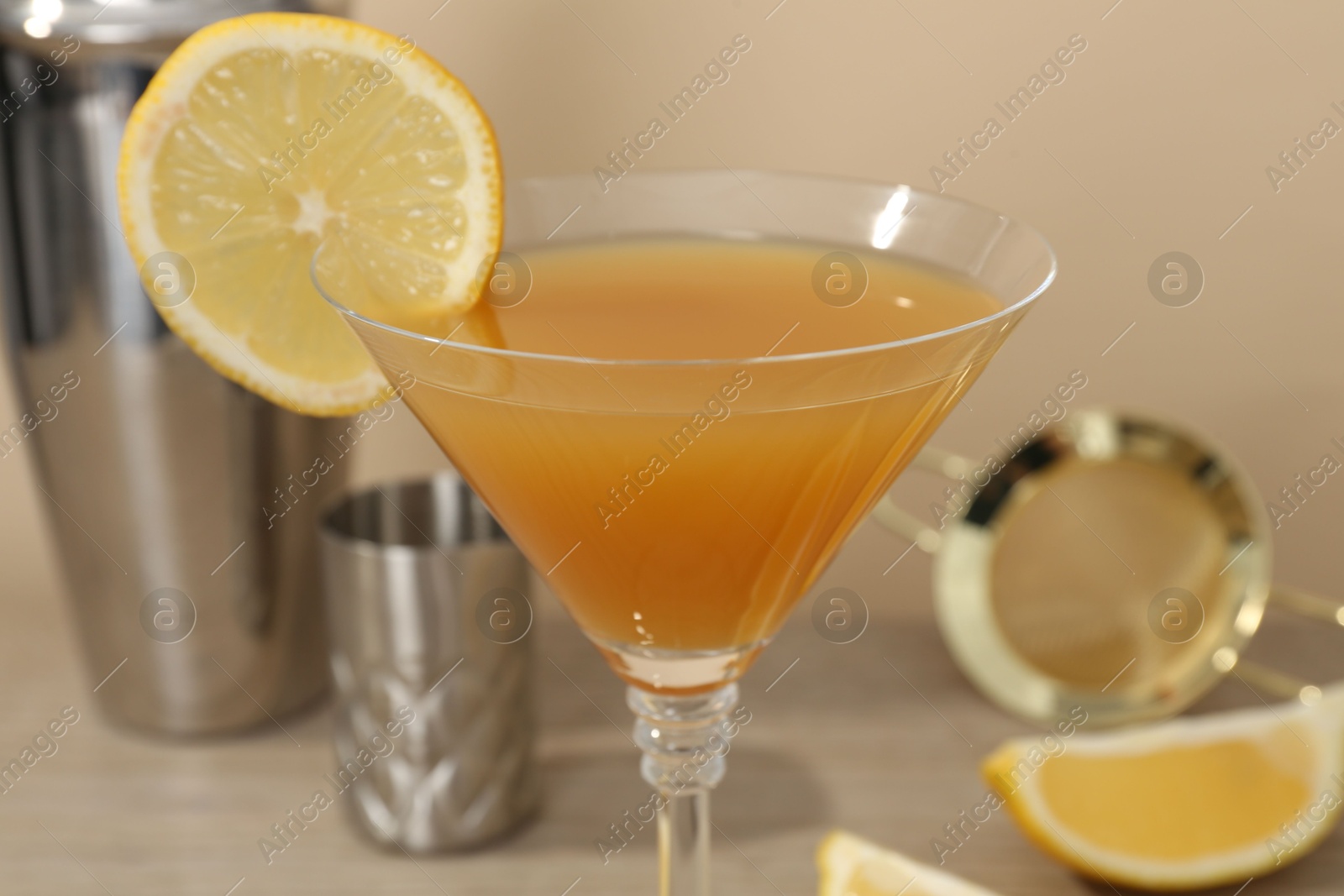 Tasty lemon cocktail in glass and bartender equipment on table, closeup Photo of Tasty lemon cocktail in glass and bartender equipment on table, closeup