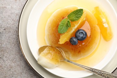 Photo of Tasty panna cotta with orange, blueberries and mint on light grey table, top view