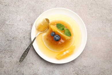 Photo of Tasty panna cotta with orange, blueberries and mint on light grey table, top view