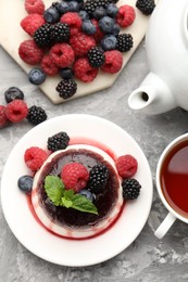 Photo of Tasty panna cotta with berries and jam on light grey table, flat lay