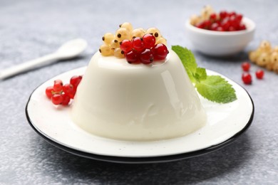 Photo of Tasty panna cotta with currants and mint on light grey table, closeup