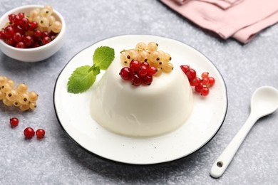 Photo of Tasty panna cotta with currants and mint on light grey table, closeup