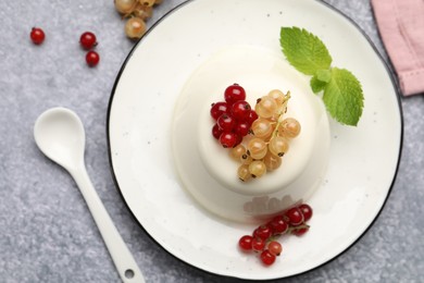 Photo of Tasty panna cotta with currants and mint on light grey table, flat lay